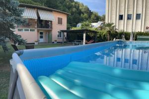 a blue swimming pool in front of a house at CASA STEFANIA con giardino a LUGANO in Grancia