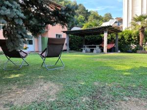 CASA STEFANIA con giardino a LUGANO في Grancia: كرسيين يجلسون في ساحة مع شرفة