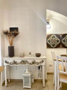 Una mesa blanca con un jarrón en una habitación en Casa di zia Pupetta en Bari