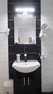 uma casa de banho com um lavatório branco e um espelho. em Aeroport - Relax Casa Victoria em Otopeni