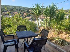 a table and four chairs on a patio with a view at Mhna guest house in Ajloun