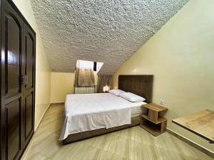 a bedroom with a bed and a ceiling at Chalet Snow Valley - Private Pool in Imouzzer Kandar