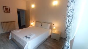 - une chambre avec un grand lit blanc et deux lampes dans l'établissement Mirdita - Casa Vacanze, à La Spezia