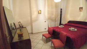 een slaapkamer met een rood bed en een stoel bij Appartamento Kiwy in Arsago Seprio