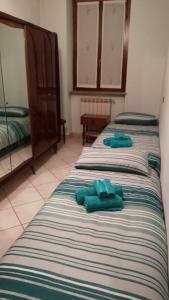 Dos toallas verdes sentadas en una cama en una habitación en Appartamento Kiwy, en Arsago Seprio