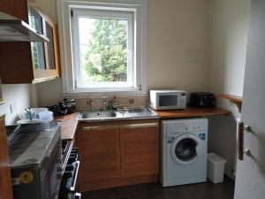 eine Küche mit einer Spüle und einer Waschmaschine in der Unterkunft SELF CATERING 2 Bedroom Flat in Edinburgh