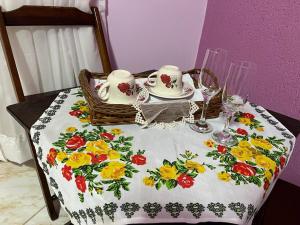 una mesa con un mantel con un set de té. en Cantinho da tia Lira, en Cabo Frío