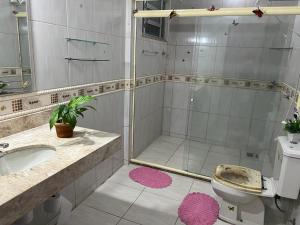 y baño con ducha, aseo y lavamanos. en Cantinho da tia Lira, en Cabo Frío