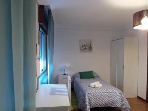 a small bedroom with a bed and a window at Casa Navarro in Vigo