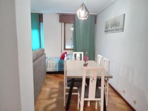 a dining room with a table and chairs and a couch at Casa Navarro in Vigo