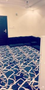 uma sala de estar com um sofá e um tapete azul e branco em شقق العزاب الفاخرة em Tabuk