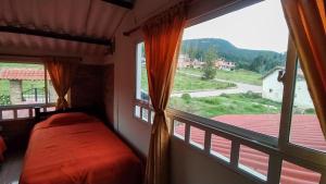 a bedroom with a bed and a large window at Posada Rural - La Isabela in Tópaga