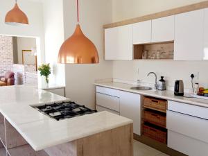 a kitchen with white cabinets and a stove top oven at Beach Garden Guesthouse with Self Catering in Swakopmund