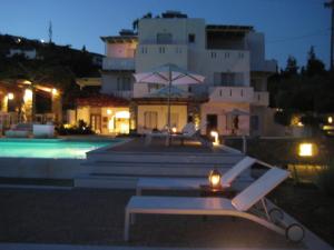 a pool in front of a building at night at Roses Beach in Parikia