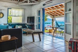 a living room with a couch and a table at Casa pé na areia na Praia da Armação em Ilhabela in Ilhabela