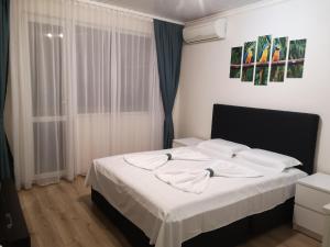 a bedroom with a large bed with white sheets at EL VERANO VARNA in Varna City