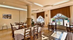 a dining room with tables and chairs in a building at Bare Hill Holiday Apartments in Kérynia