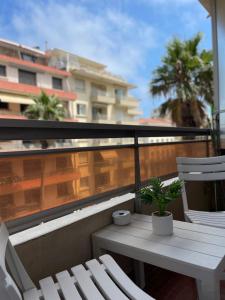 a balcony with a white table and two chairs at Idéalement situé, vue mer & Parking privée gratuit in Canet-en-Roussillon