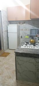 una cucina con piano cottura e frigorifero bianco di Dar abd essalam a Moulay Yacoub
