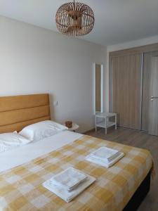 a bedroom with a large bed with two towels on it at The Roof Elite in Portimão