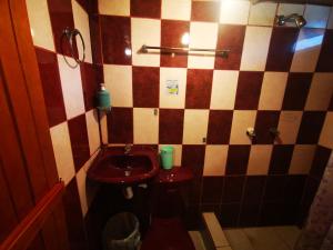 baño con aseo rojo y lavamanos en LA TRANQUILIDAD en Mindo
