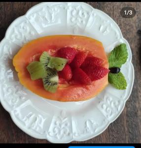 a white plate with a fruit dessert on it at Bangalôs Meu Jardim Caraíva in Caraíva