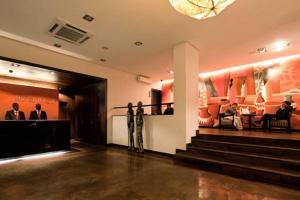 Hotel Tivoli Beira في بيرا: لوبي فيه ناس جالسين كراسي في مبنى