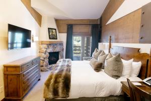 1 dormitorio con 1 cama grande y chimenea en Luxury One Bedroom with Mountain View apartment hotel en Park City