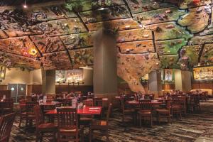 a dining room with tables and chairs and a ceiling with paintings at New York-New York in Las Vegas