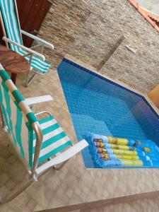 - une vue sur la piscine dotée de 2 chaises longues et d'une piscine dans l'établissement Casa de praia verde mar, à Itanhaém