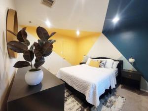 um quarto com uma cama e um vaso de plantas em Haus of Colours - 7 beds - GRB - Downtown em Houston