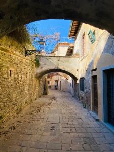 eine Gasse in einer Altstadt mit einem Torbogen in der Unterkunft Acacia Firenze - Giglio in Florenz