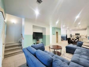 uma sala de estar com um sofá azul e uma mesa em Haus of Colours - 7 beds - GRB - Downtown em Houston