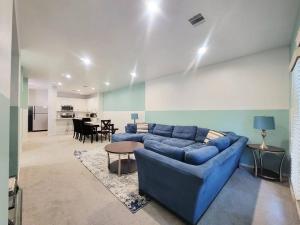uma sala de estar com um sofá azul e uma mesa em Haus of Colours - 7 beds - GRB - Downtown em Houston