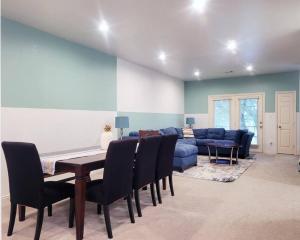 uma sala de estar com um sofá azul e uma mesa e cadeiras em Haus of Colours - 7 beds - GRB - Downtown em Houston