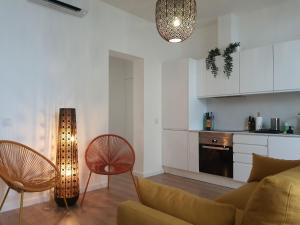 uma sala de estar com um sofá e cadeiras e uma cozinha em Exotic Fusion: Coffee & Radio em Lisboa