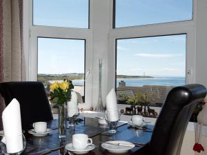 a dining room table with a view of the ocean at Norland B & B in Lossiemouth