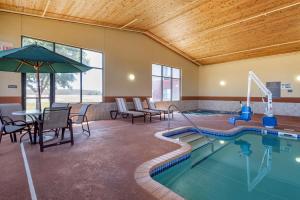 a pool with chairs and a table and an umbrella at Best Western Plus Chelsea Hotel in Monticello