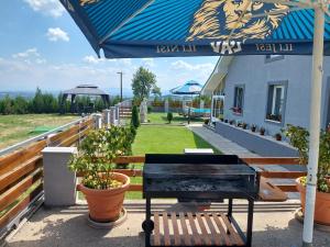 eine Terrasse mit einer Bank und einem Sonnenschirm in der Unterkunft Vila Boba Bor in Zlot