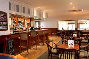 a restaurant with a bar and tables and chairs at Best Western Ipswich Hotel in Ipswich