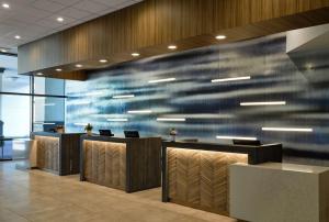 un vestíbulo de oficina con una pared azul con escritorios y sillas en Sonesta Irvine en Irvine
