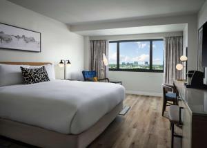 a hotel room with a bed and a large window at Sonesta Irvine in Irvine