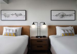 um quarto com 2 camas e uma mesa de cabeceira com 2 candeeiros em Sonesta Irvine em Irvine