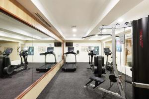 a gym with several treadmills and elliptical machines at Rydges Darling Square Apartment Hotel in Sydney
