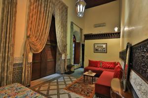 a living room with a red couch and a door at Riad Moulaydriss et Giacomo in Fez