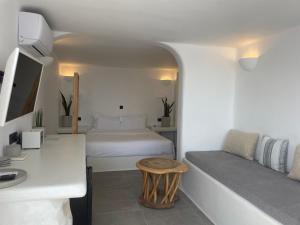 um quarto com uma cama, uma secretária e uma mesa em Nomikos Villas em Fira