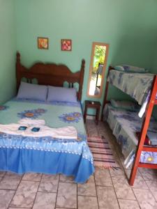 een slaapkamer met een stapelbed en een spiegel bij Pousada Cajueiro in Itaúnas