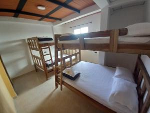 Cette petite chambre comprend 2 lits superposés et une fenêtre. dans l'établissement Ekolores Hostal - PARQUE DEL CAFÉ - 313-468-08-41, à Montenegro