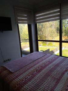 - une chambre avec un grand lit et une grande fenêtre dans l'établissement Casa en Pingueral 4, à Tomé