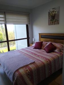a bedroom with a bed and a large window at Casa en Pingueral 4 in Tomé